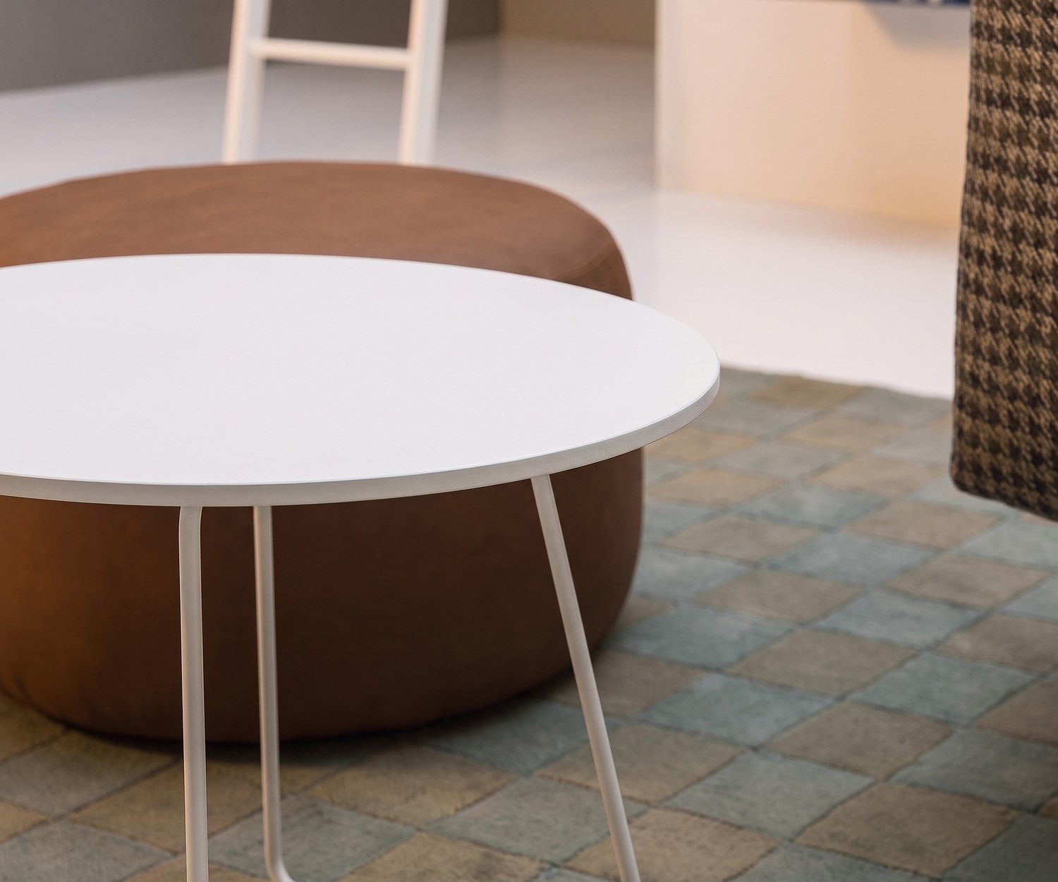 Novamobili Beistelltisch Orbis im Wohnzimmer neben braunem Pouf, runder Couchtisch in Weiß, modernes Design.
