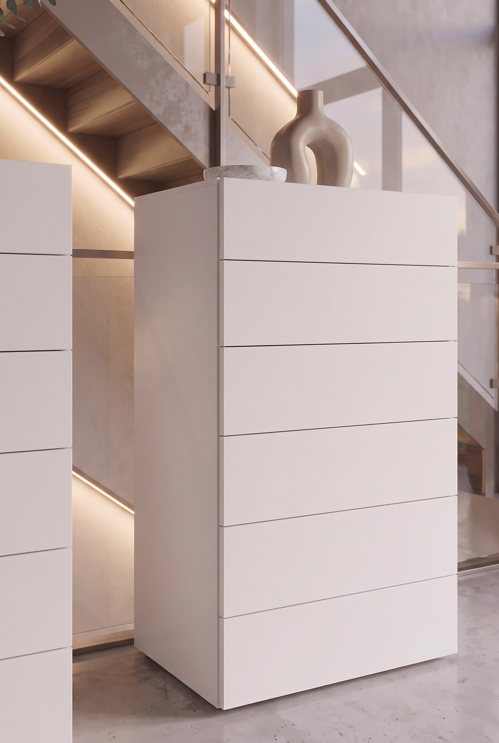 Detailopname van een witte hoge ladekast met greeploze laden en een fijne schaduwvoeg.