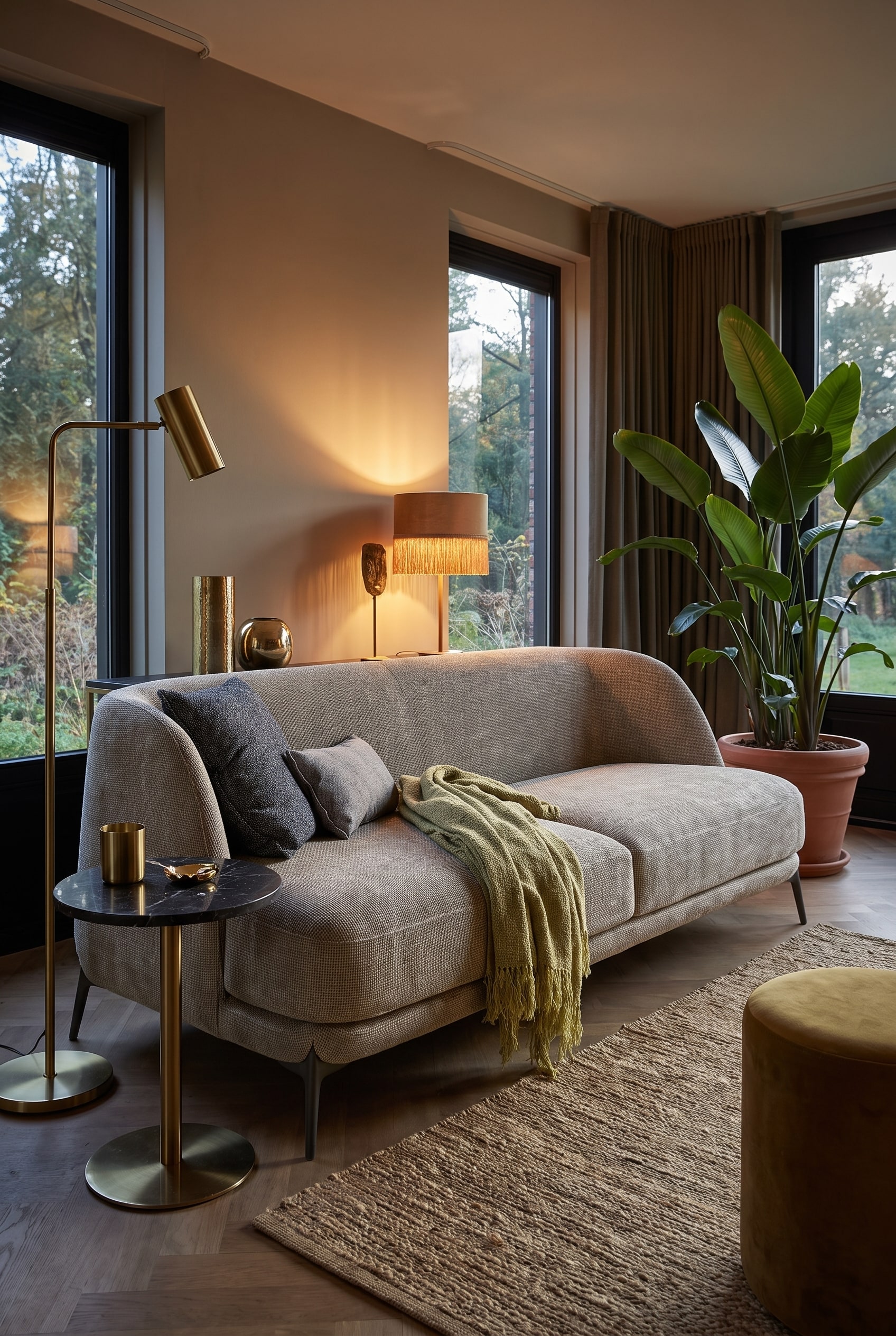 Salon de style Boho-Glamour avec un canap&eacute; en velours de forme organique dans une teinte chaude, compl&eacute;t&eacute; par des d&eacute;tails en laiton et de grandes plantes