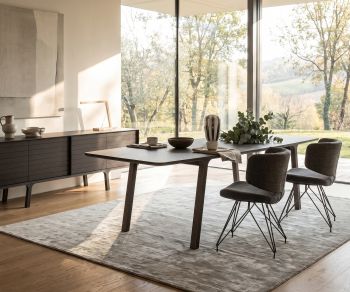 al2 mobius 001 dining table in a modern dining room, made of dark wood veneer, with matching chairs and large window