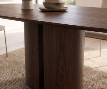 al2 el-it c 001 design dining table in dark wood veneer with cylindrical pedestal base on a woven rug.