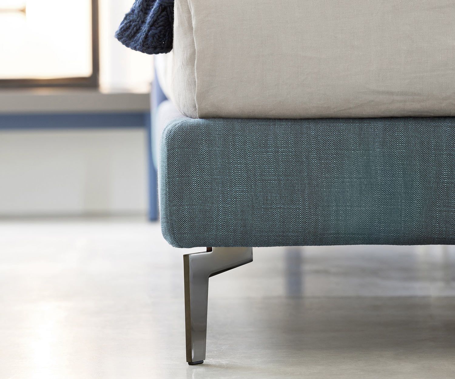 Detail of the narrow foot of the Novamobili designer upholstered bed Margot