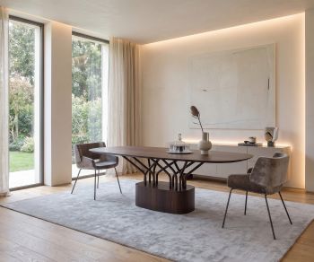 al2 wood-oo 001 a oval wooden dining table in a minimalist dining room with grey chairs and a large rug.