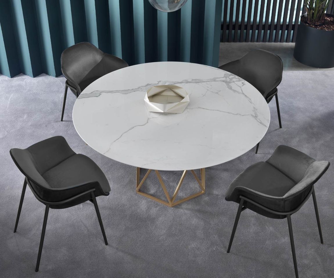 Cosy armchair in the dining room with marble table arranged as an ensemble of 4