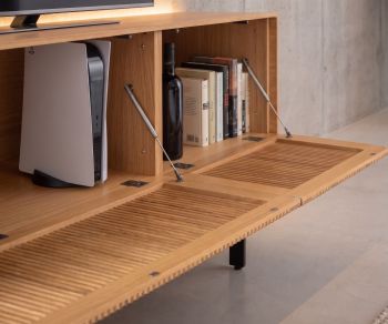 Punt Malmö oak TV lowboard with slatted drop-down door and interior storage for media console in a modern living room.