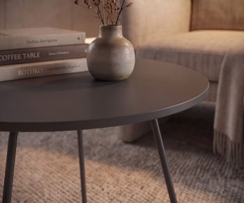Novamobili side table Orbis in the living room. Round grey coffee table next to an armchair with books and vase.